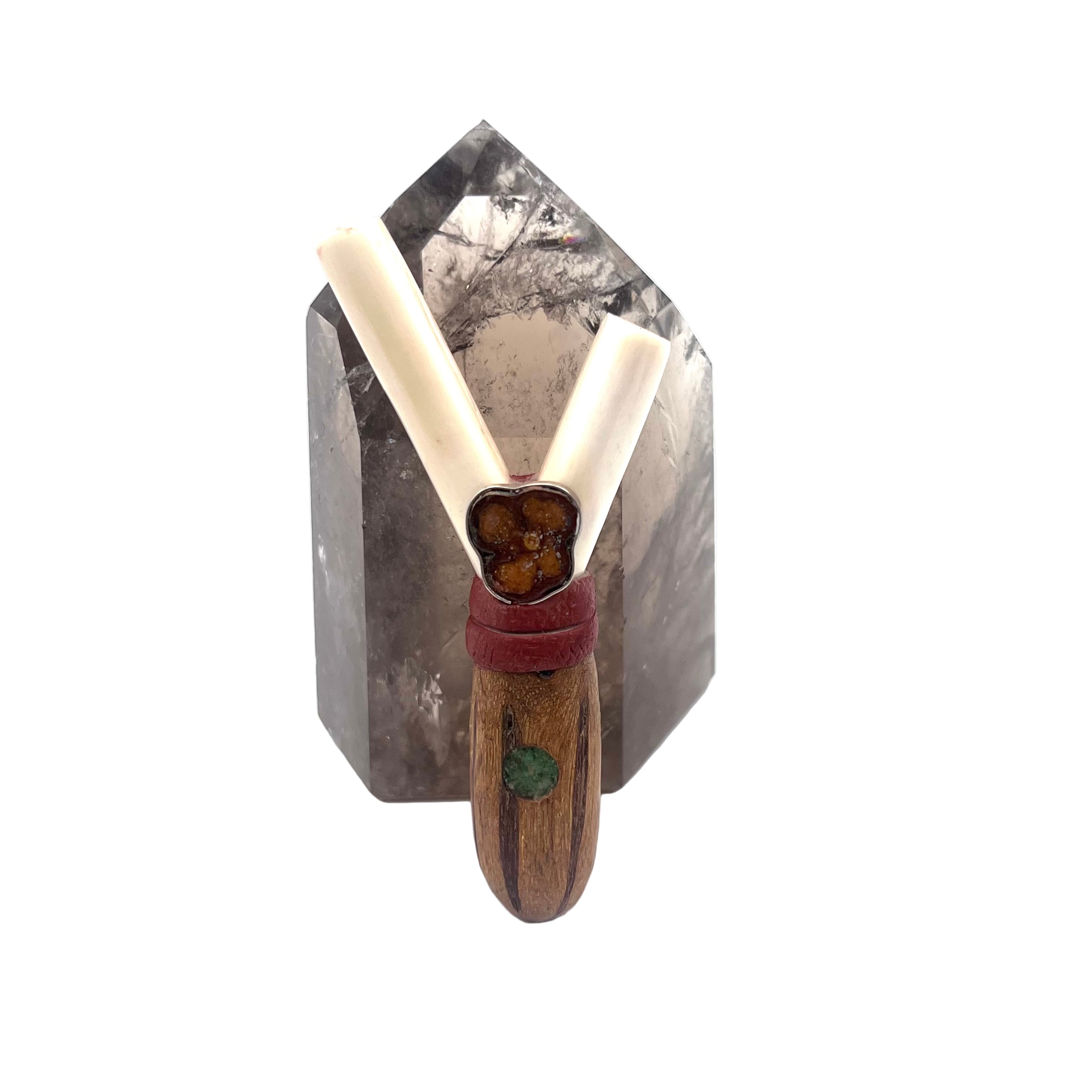 Handcrafted Blue Eye Kuripe made from bone and Amazonian wood with stone inlay — a ceremonial self-applicator symbolizing clarity, protection, and spiritual vision. Shown next to a smokey quartz crystal.