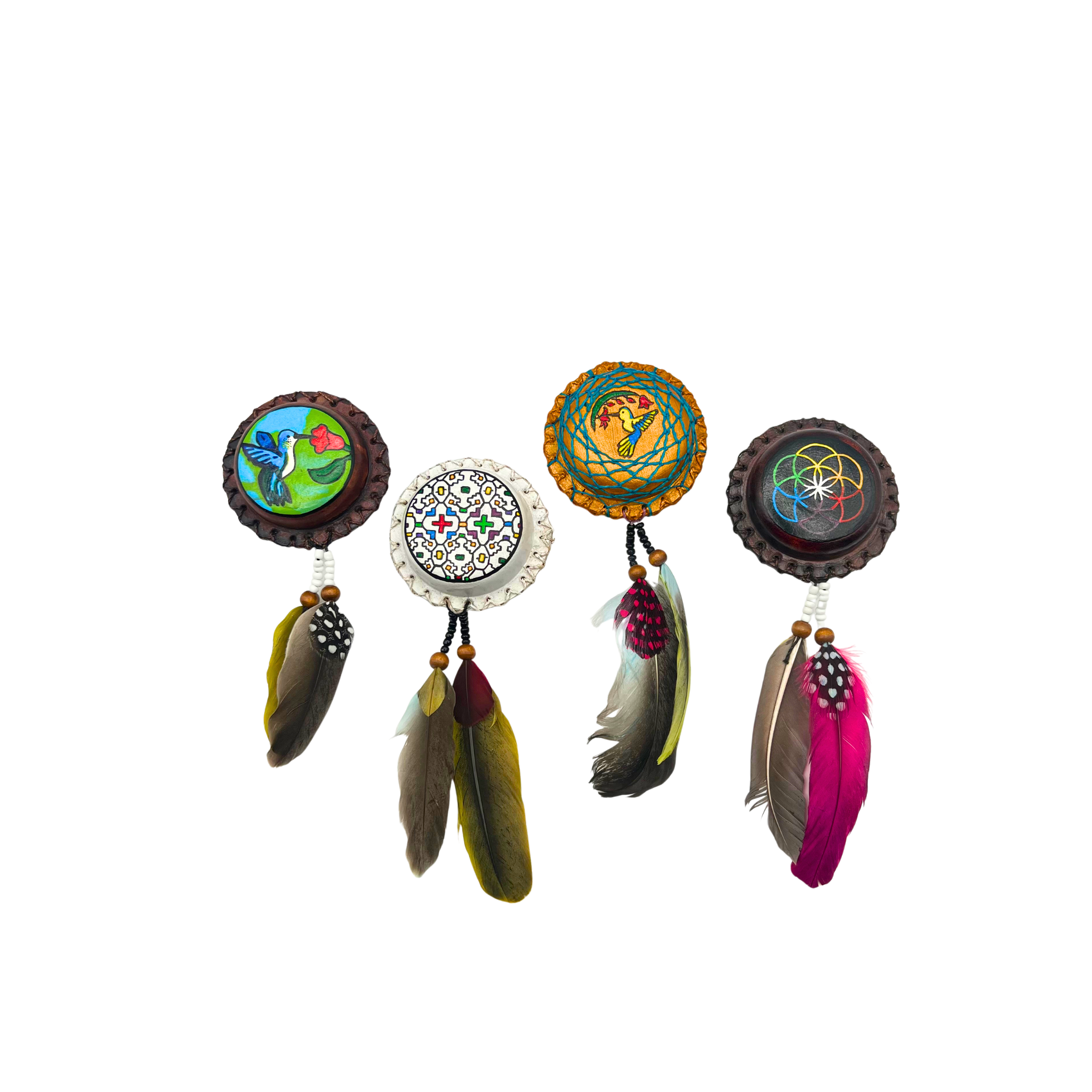 Handcrafted leather palm shakers made in Peru by Indigenous artisans, featuring attached feathers and hand-painted designs in Icaro, Hummingbird, flower of life and Gold Hummingbird variants: lightweight ceremonial instruments for rhythm, music, and spiritual connection.