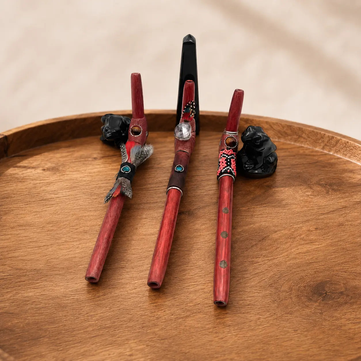 Three handcrafted Tepi "L" Hapé serving applicators by Collective Journey Art, made from Palo Sangre wood in feathered, leather-wrapped, and colorful beaded designs.